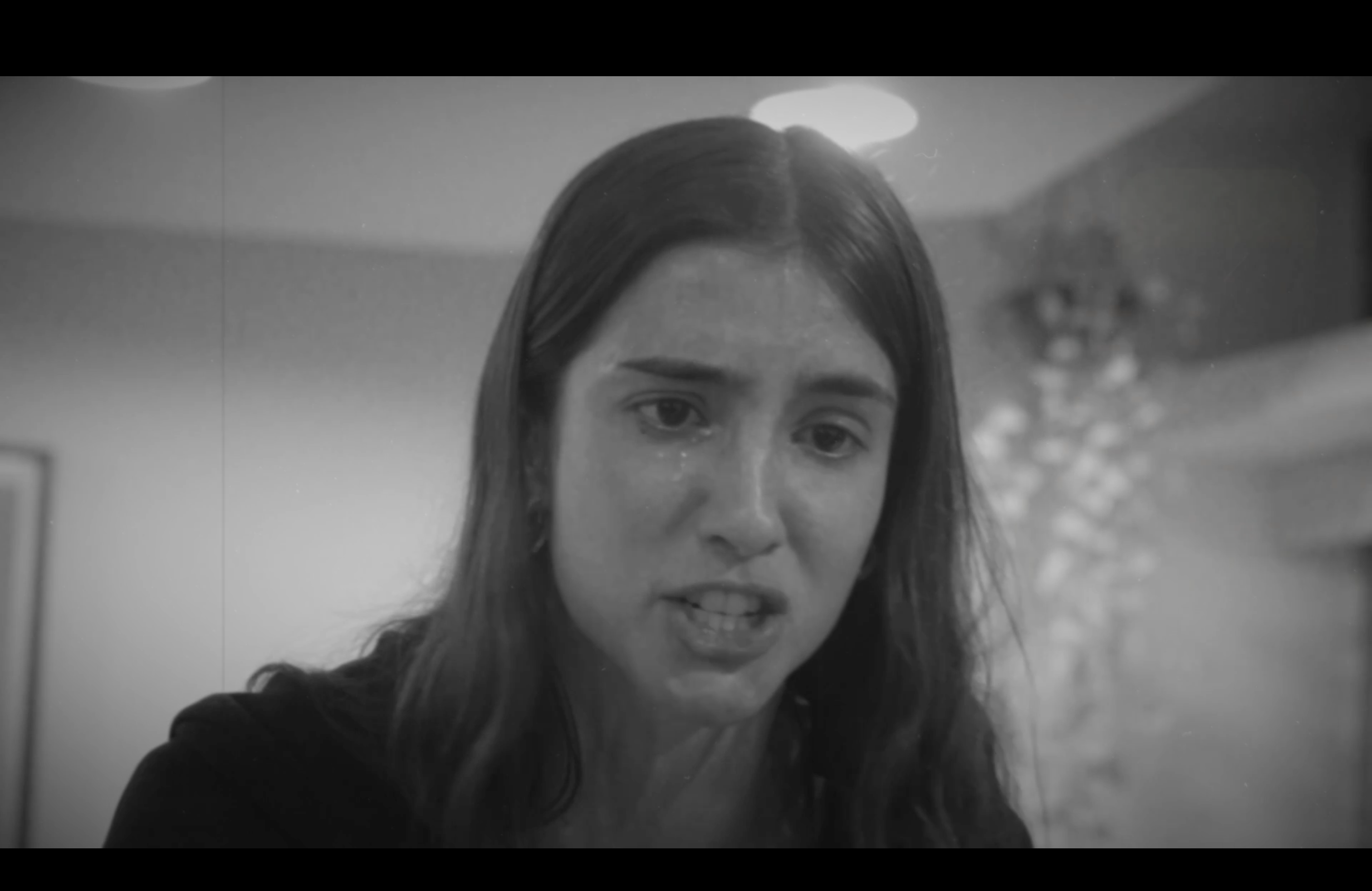 Photo of a silhouette of 2 dancers posing in front of a red curtain.