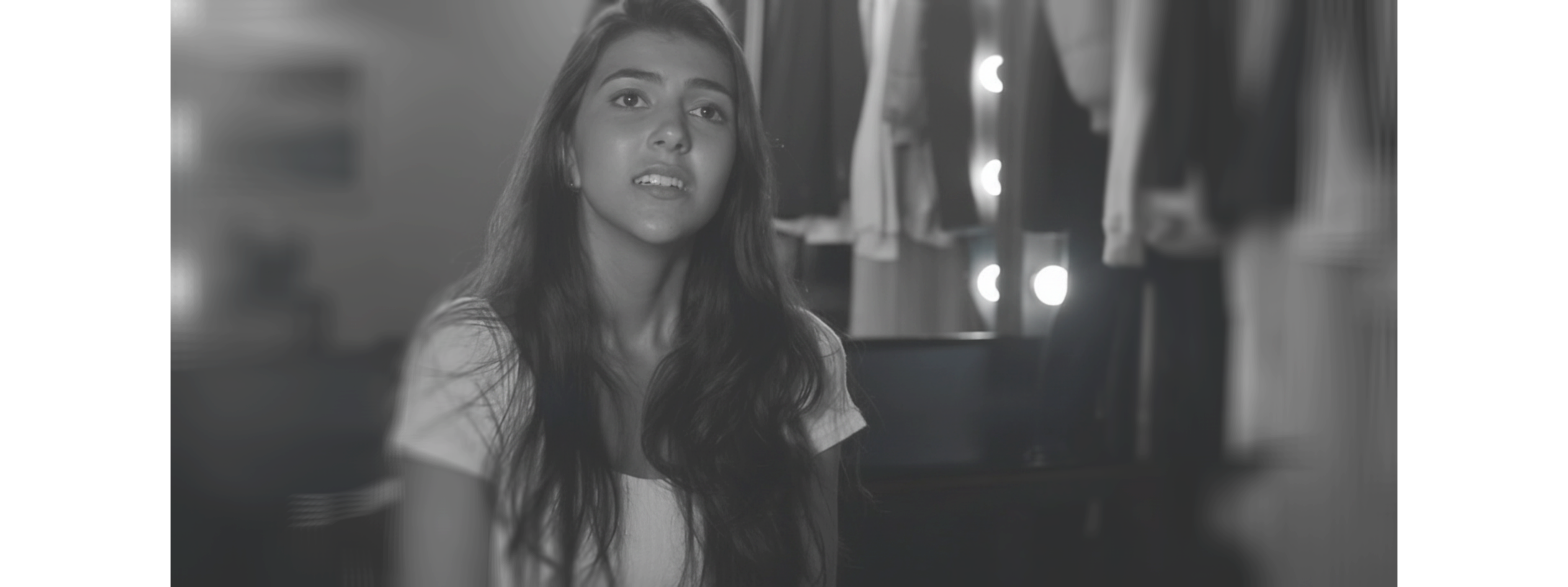 Black and white photo of a women performing modern dance on a dark background.